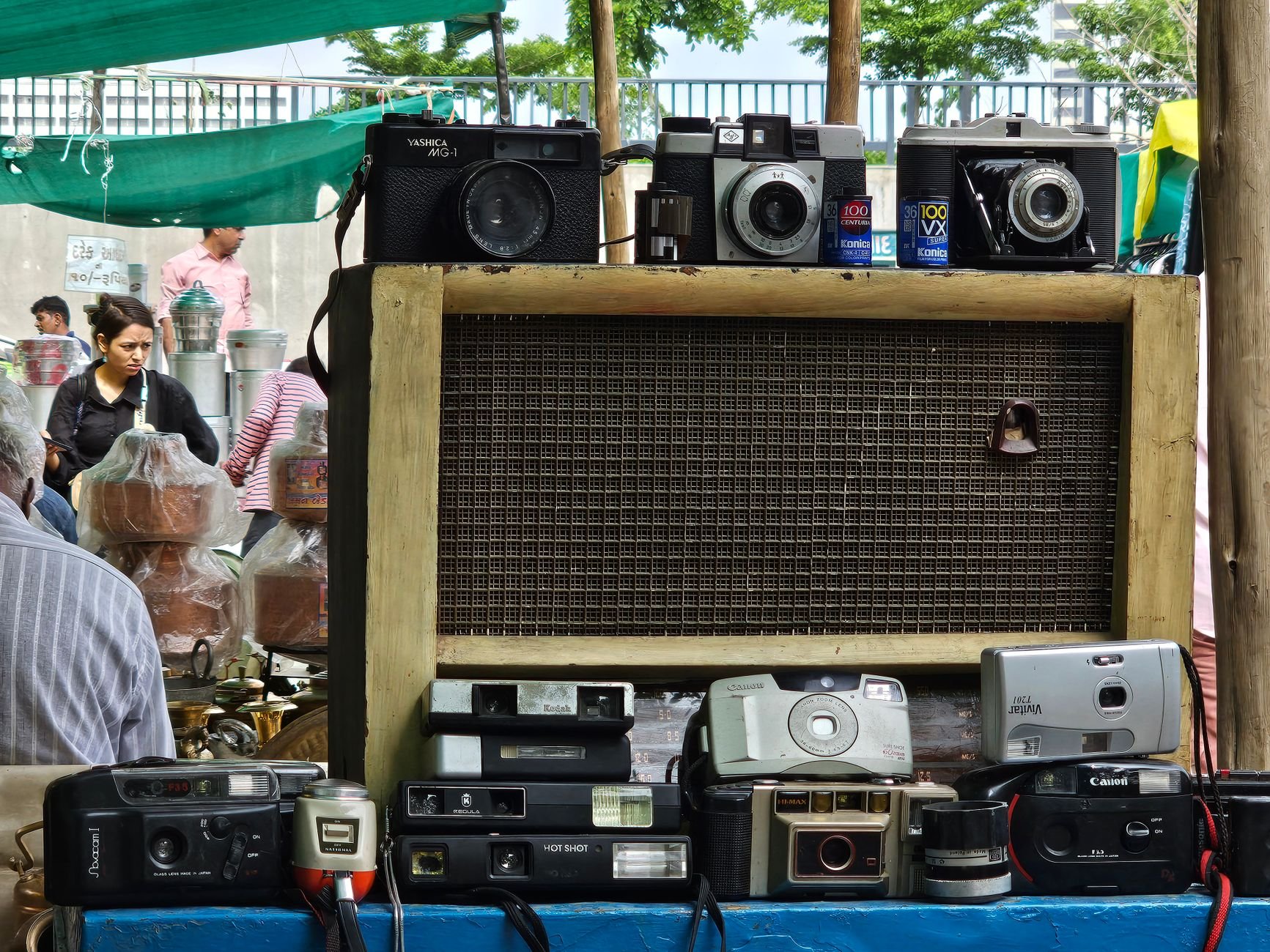 An assortment of vintage cameras on display at an outdoor market stall.
